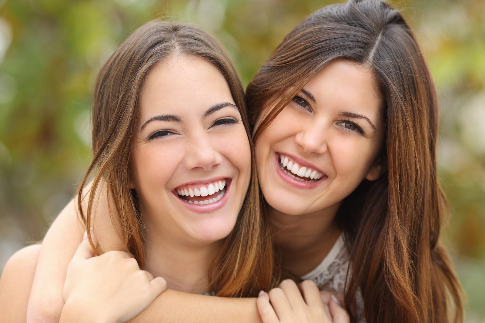 dos mujeres sonriendo mostrando su salud dental