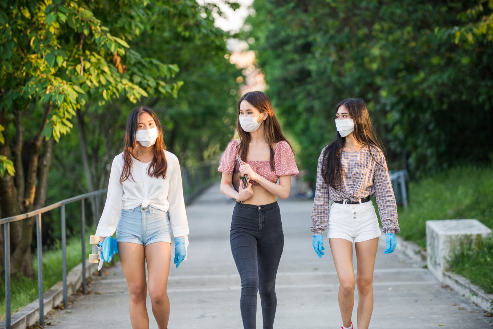 tres mujeres caminando con mascarilla y manteniendo el distanciamiento social para prevenir el contagio de covid-19